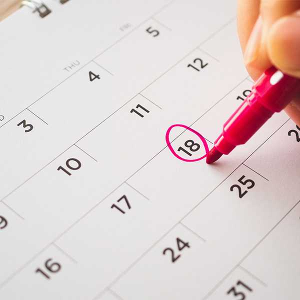A person marking a date on a calendar.
